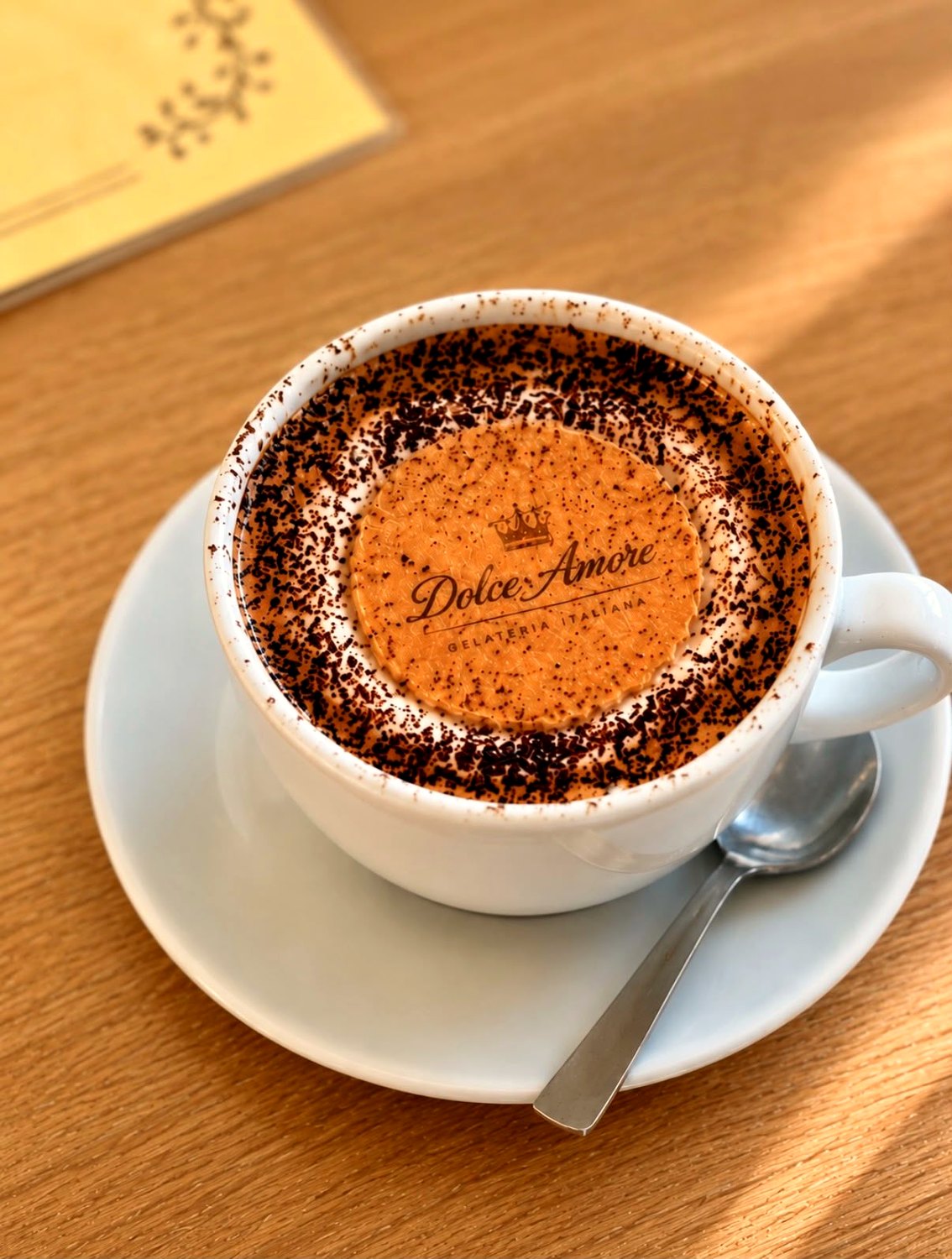 A Dolce Amore cappuccino topped with a branded chocolate wafer